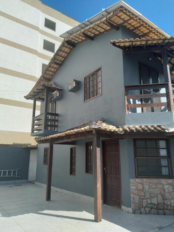 ein Gebäude mit einer Holztür und einem Balkon in der Unterkunft Casa Temporada Rio das Ostras in Rio das Ostras