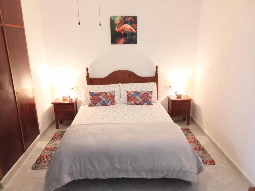 a bedroom with a large bed with two night stands at Casa Palomar in Alcaudete