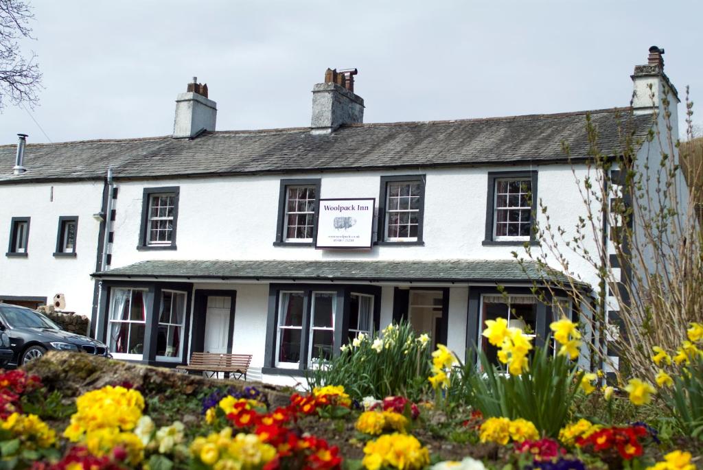 ein weißes Gebäude mit Blumen davor in der Unterkunft Woolpack Inn in Eskdale