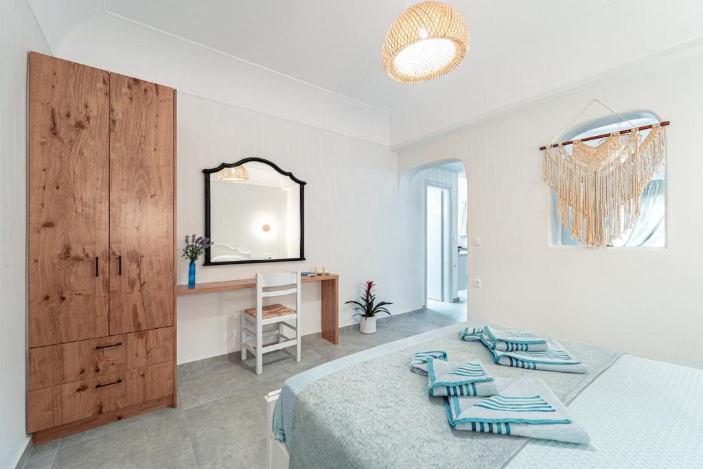 a bedroom with a bed and a mirror and a table at Ostria Apartments in Akrotiri