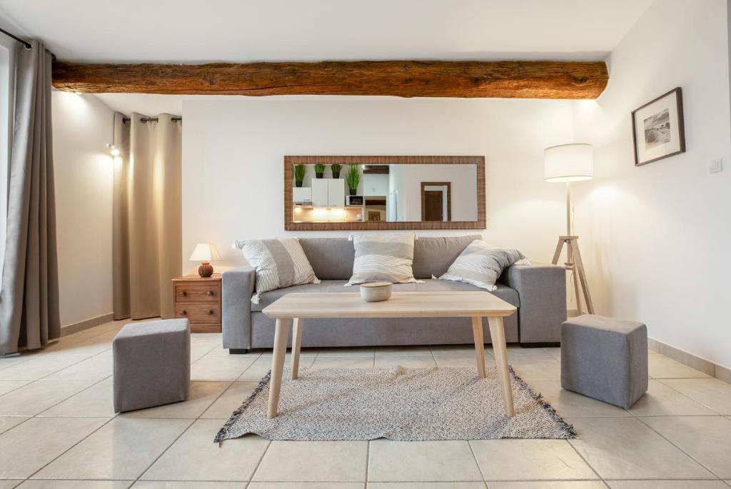 un salon avec un canapé et une table dans l'établissement Nézignan l évêque 3km de Pezénas Suit'Appart 70m2, à Nézignan-lʼÉvêque