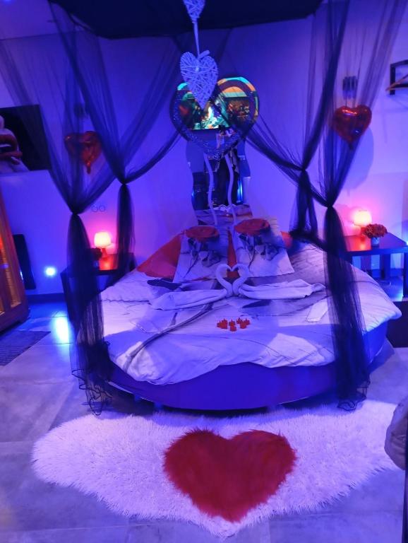 - une chambre avec un lit avec un cœur dans l'établissement spa privatif Dydy's love saint amand les eaux, à Lecelles