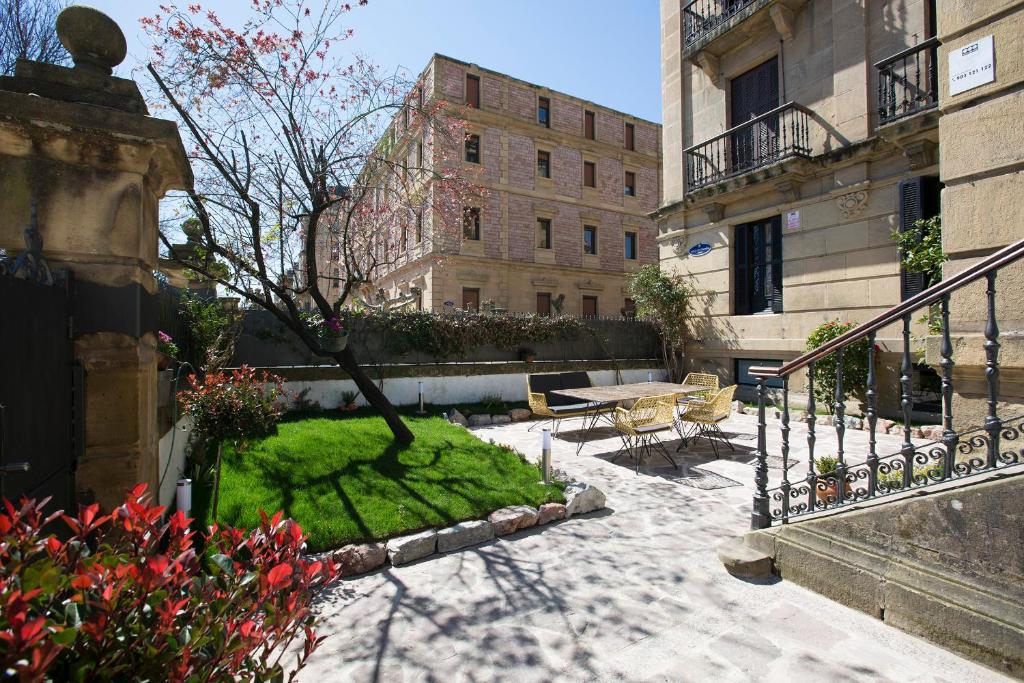 un patio con una mesa y un árbol y un edificio en Guest House Ibaia Et Arramak, en San Sebastián