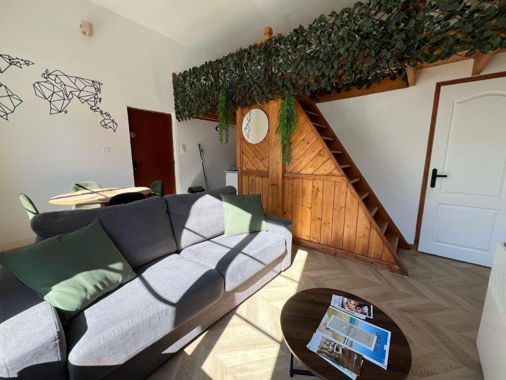 un salon avec un canapé et un escalier dans l'établissement Appartement vue sur la Basilique - Boulogne-sur-mer, à Boulogne-sur-Mer