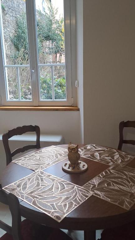 une table avec un gâteau devant une fenêtre dans l'établissement Appartement calme, lumineux, 4 personnes, parking, à Mende