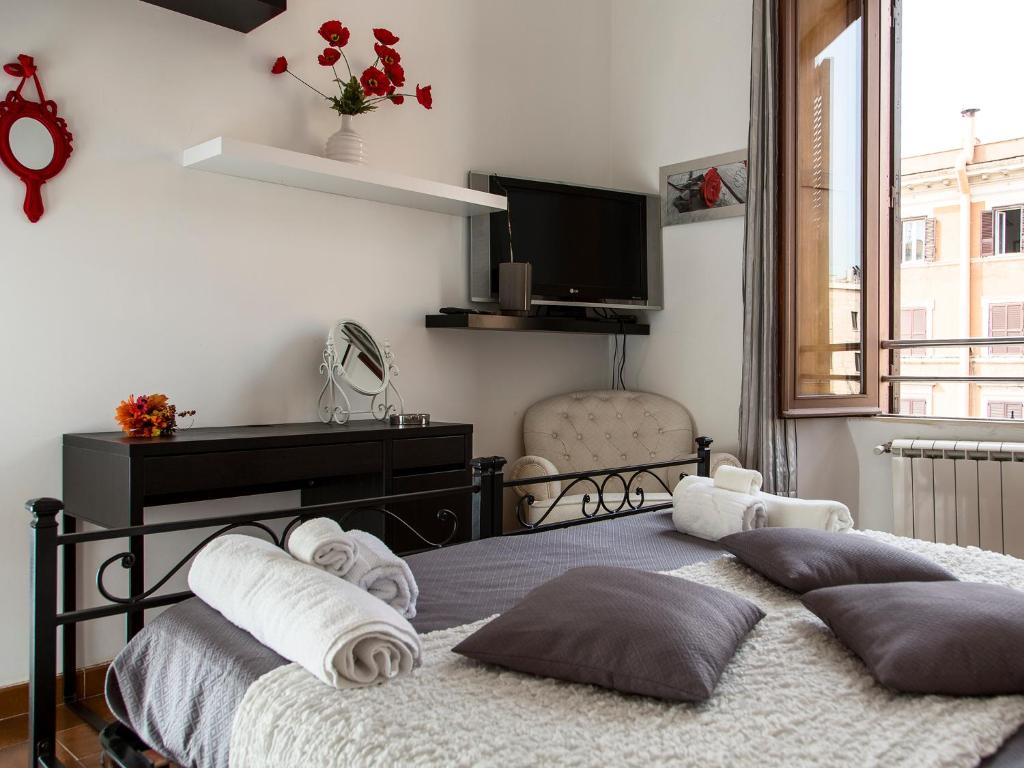 1 dormitorio con 2 camas con almohadas y piano en Manzoni Holiday Apartment, en Roma