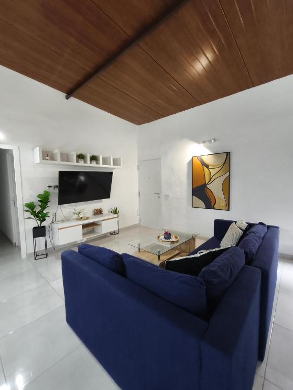 a living room with a blue couch and a table at APARTAMENTOS MALPAÍS in Los Barros
