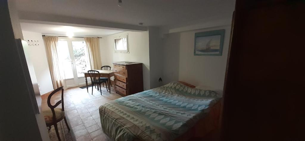une chambre avec un lit, un bureau et une table dans l'établissement Studio indépendant au calme proche d'Aix en Provence, à Aix-en-Provence