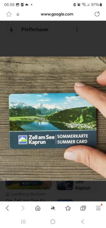 ręka trzymająca kartę ze zdjęciem jeziora w obiekcie Adler Kaprun, Golf 'n' Ski and Mountain Biking. w Kaprunie