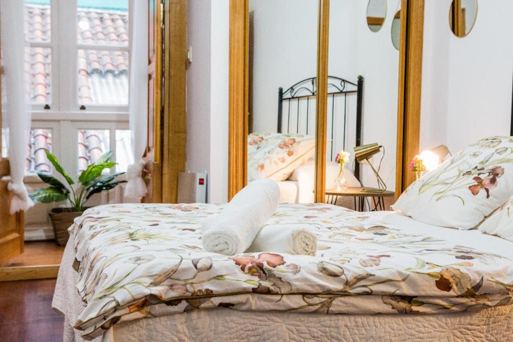 a bedroom with a bed with a mirror at Pensión 5 Caminos in Santiago de Compostela