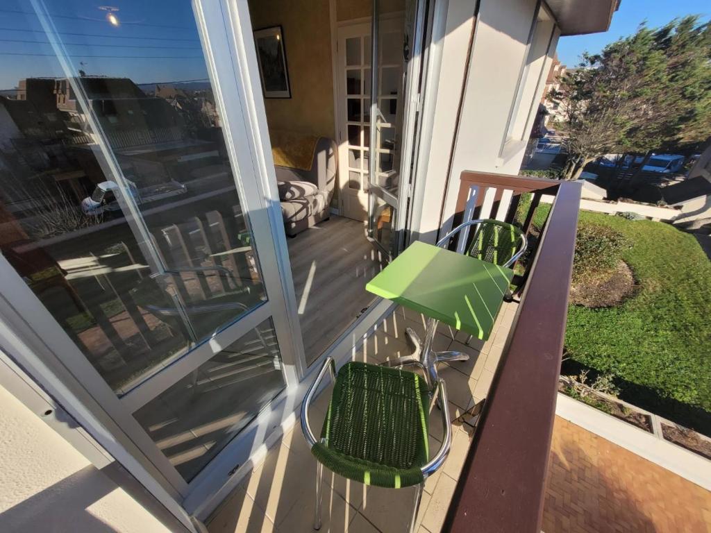 un balcon avec deux chaises et une table dans l'établissement 2 Pièces Résidence EVENTAIL et MER, à Cabourg