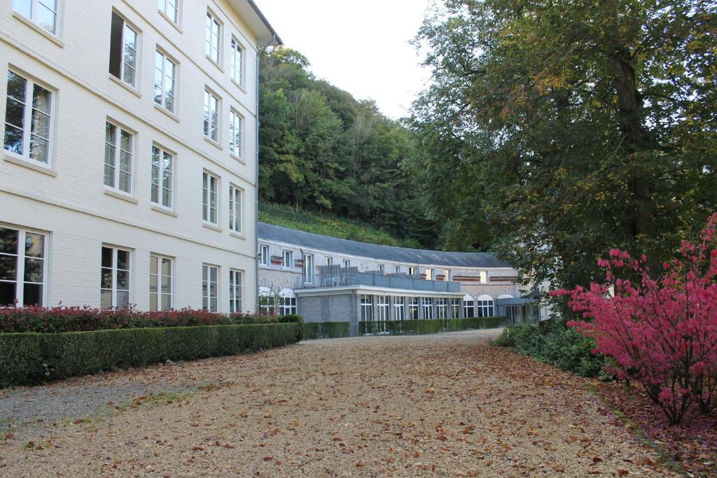 a large white building with a lot of flowers next to it at Castel de Pont-a-Lesse in Dinant