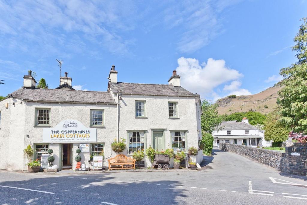 un edificio blanco en medio de una calle en Bridge Cottages, Old Post and Bridge Suite, Sleeps 8, en Coniston
