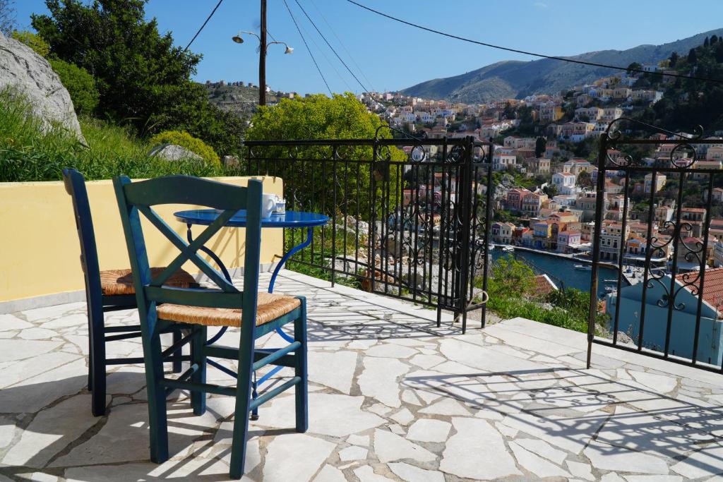 una mesa y una silla en un patio con vistas a la ciudad en Panoramic View House, en Symi