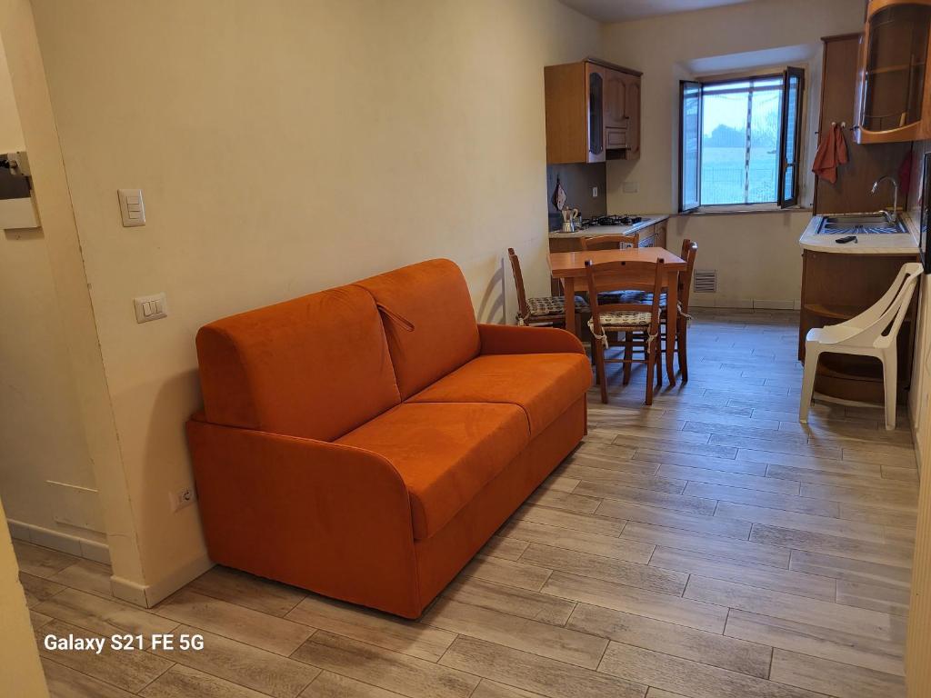 a living room with a couch and a kitchen at Grazioso appartamento con deposito bici S. Miniato in San Miniato