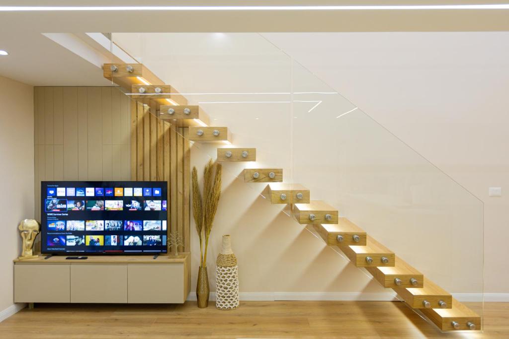 a staircase in a room with a tv and a stair case at Arial Lofts in Vlorë
