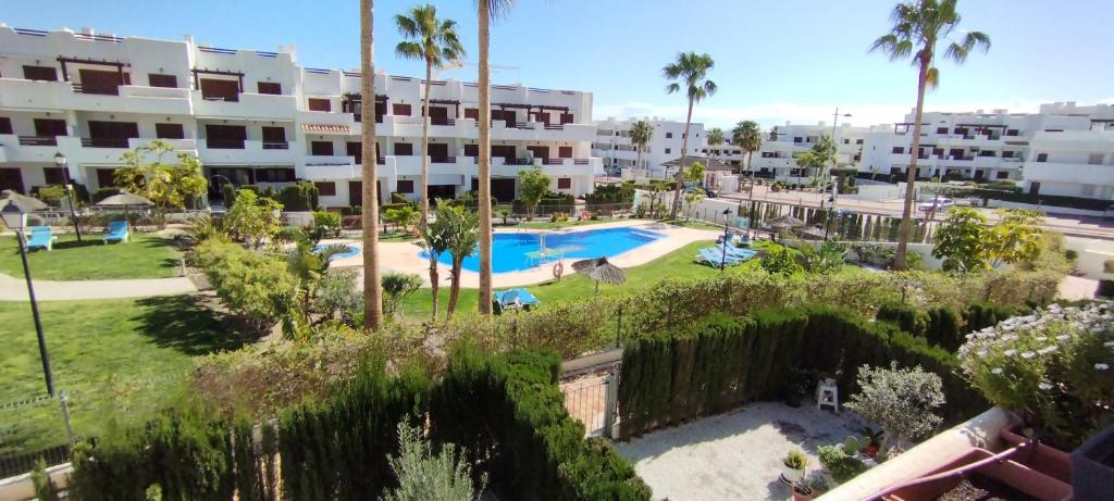 an apartment complex with a swimming pool and palm trees at cal'Nathalie in San Juan de los Terreros