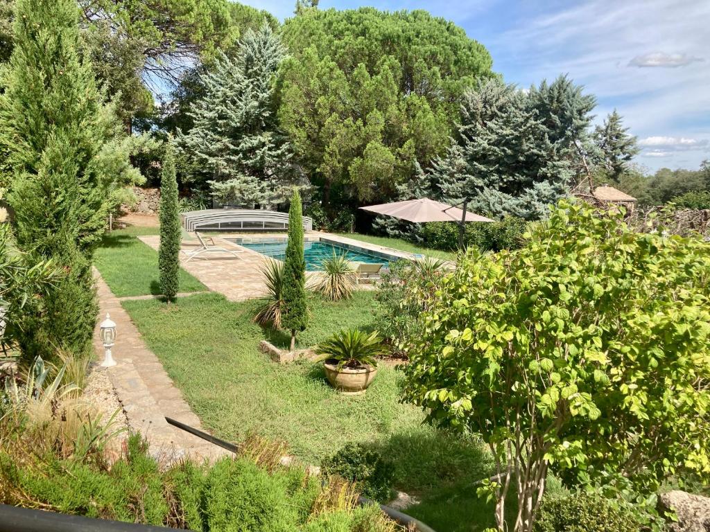 un jardin avec une piscine et quelques plantes dans l'établissement Le Mimosa des Cévennes, à Anduze