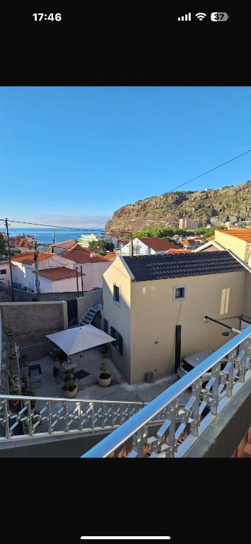 a balcony of a building with a table and umbrella at House Dino & Telma in Machico