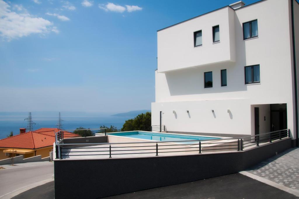 ein Gebäude mit einem Pool neben einem Gebäude in der Unterkunft Whitehouse Apartments in Makarska