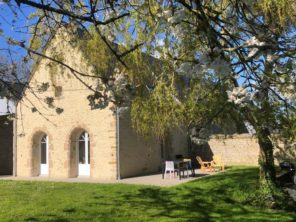 a building with chairs and a table in a yard at Gite 4 places, le Domaine de la Vallée in Saint-Martin-de-Varreville