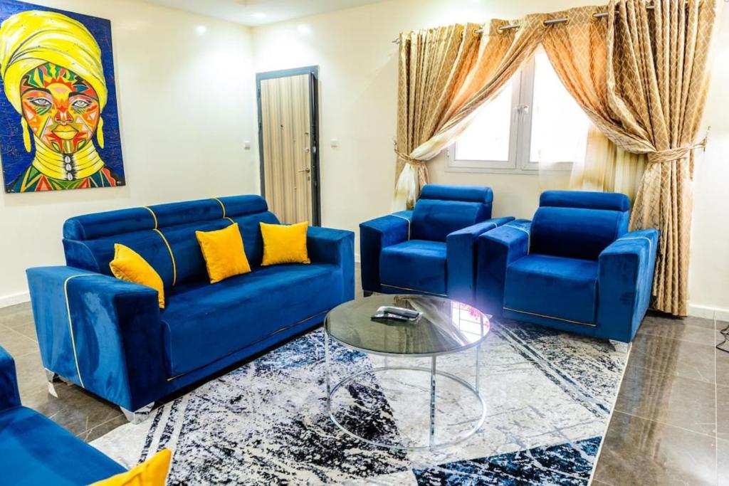 a living room with blue couches and a glass table at Appartement Somone , Sall Residence in Mbour