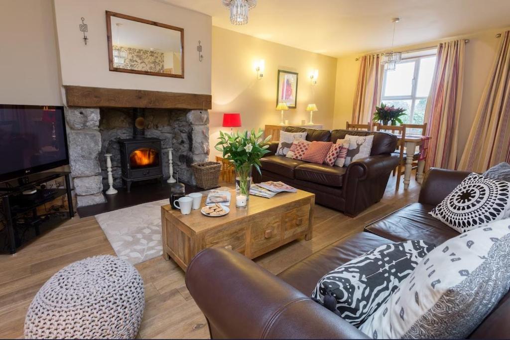 a living room with a couch and a fireplace at Luxury Cosy Cottage in Criccieth