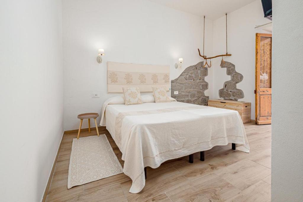 - une chambre avec un grand lit et une couverture blanche dans l'établissement Nott'e Die, à Olbia
