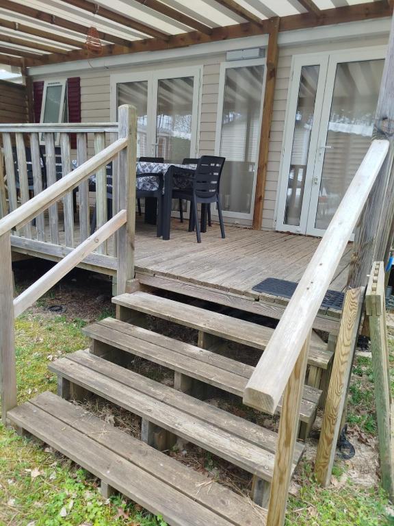 une terrasse en bois avec une table et des chaises sur une maison dans l'établissement MH 353 LUMINOSA 3chambres et 2 salles de bains dans camping 4 étoiles, à Saint-Julien-en-Born