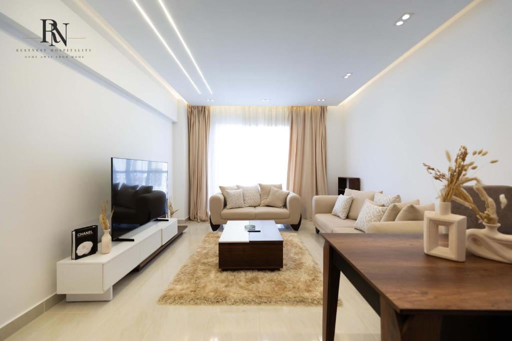 ein Wohnzimmer mit Sofa und Fernseher in der Unterkunft Spacious 2 BDR Apartment In Rehab City in Burg el-Ḥudûd