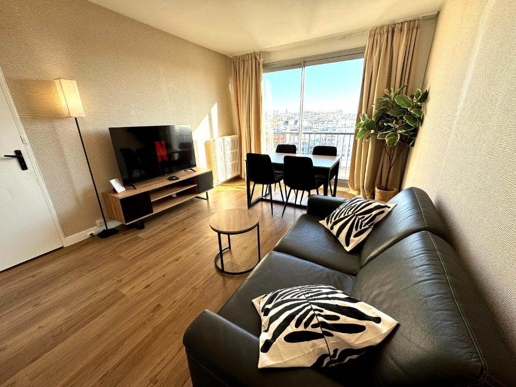 un salon avec un canapé et une table avec des chaises dans l'établissement Nid douillet et convivial à Gambetta, Paris 20ème, à Paris