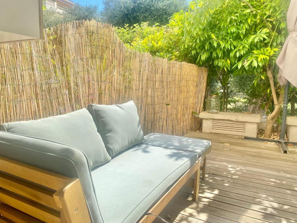 un canapé assis sur une terrasse avec une clôture dans l'établissement Studio cosy, terrasse, parking à Carnolès, à Menton
