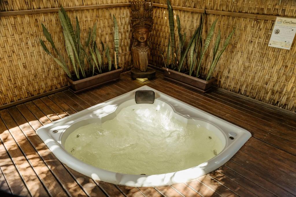 a bath tub in a room with two plants at Espaço CurAmar - Praia de Itamambuca in Ubatuba