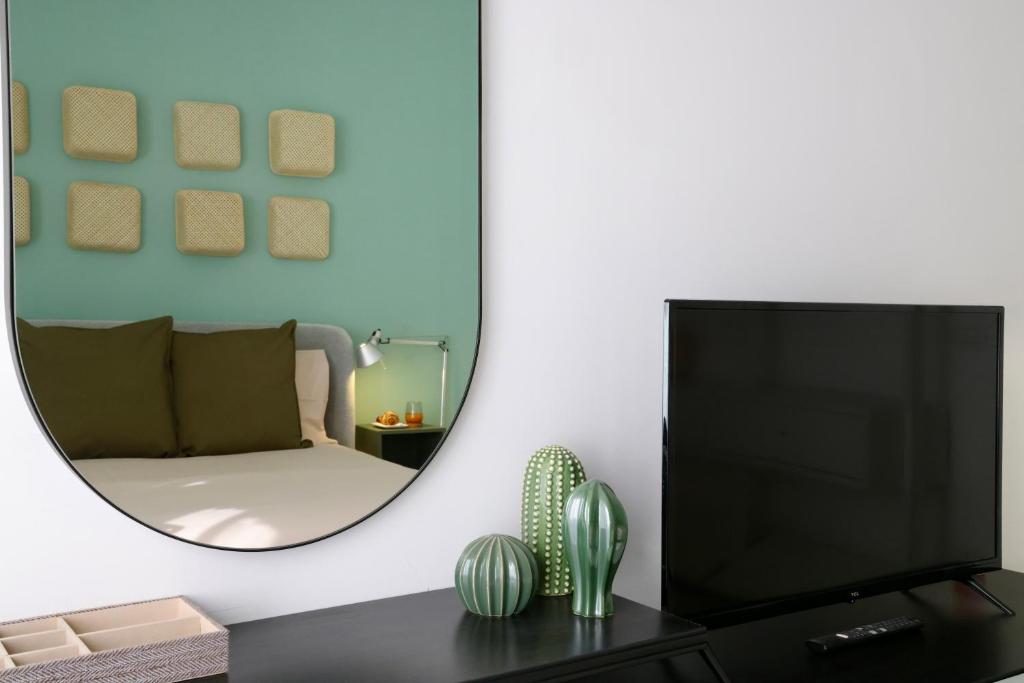 ein Wohnzimmer mit Fernseher und Spiegel in der Unterkunft Doma Centro 5 in Gela