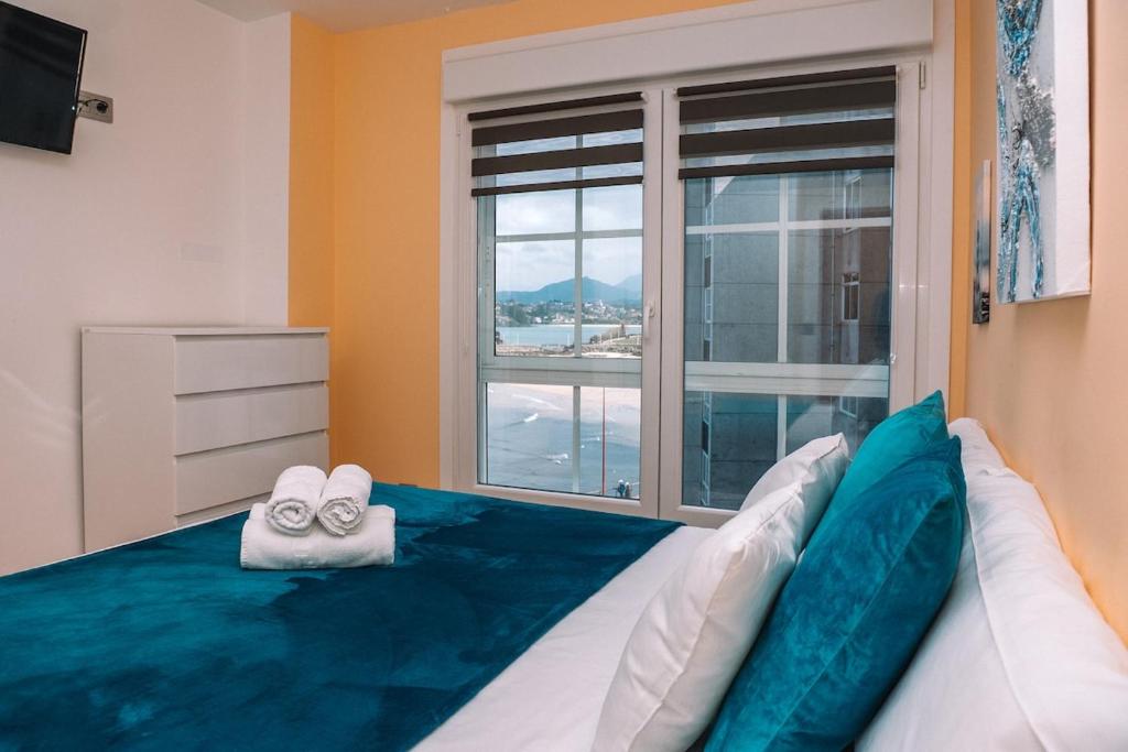 バイヨーナにあるMágicas vistas al mar en Baiona by CABANA Rentalsのベッドルーム1室(スリッパ付きのベッド1台、窓付)
