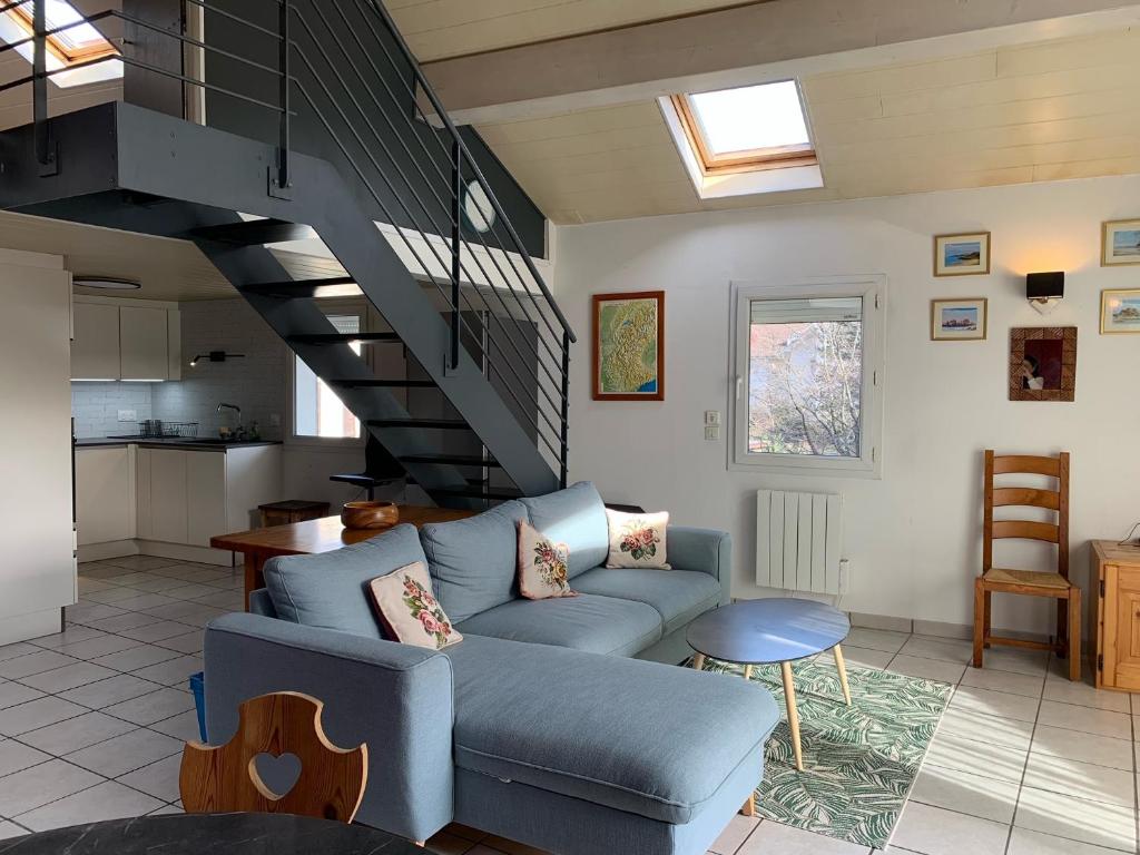 - un salon avec un canapé bleu et un escalier dans l'établissement Thonon Concise apt with mezzanine, à Thonon-les-Bains
