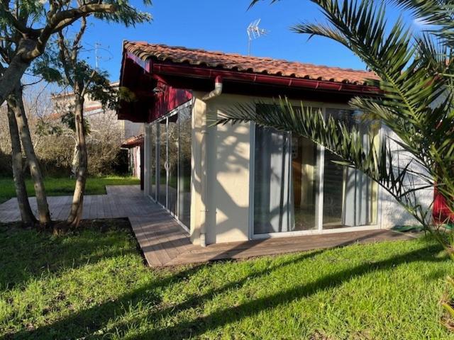 une petite maison avec une véranda et un palmier dans l'établissement Maison Trinque Dit, à Audenge