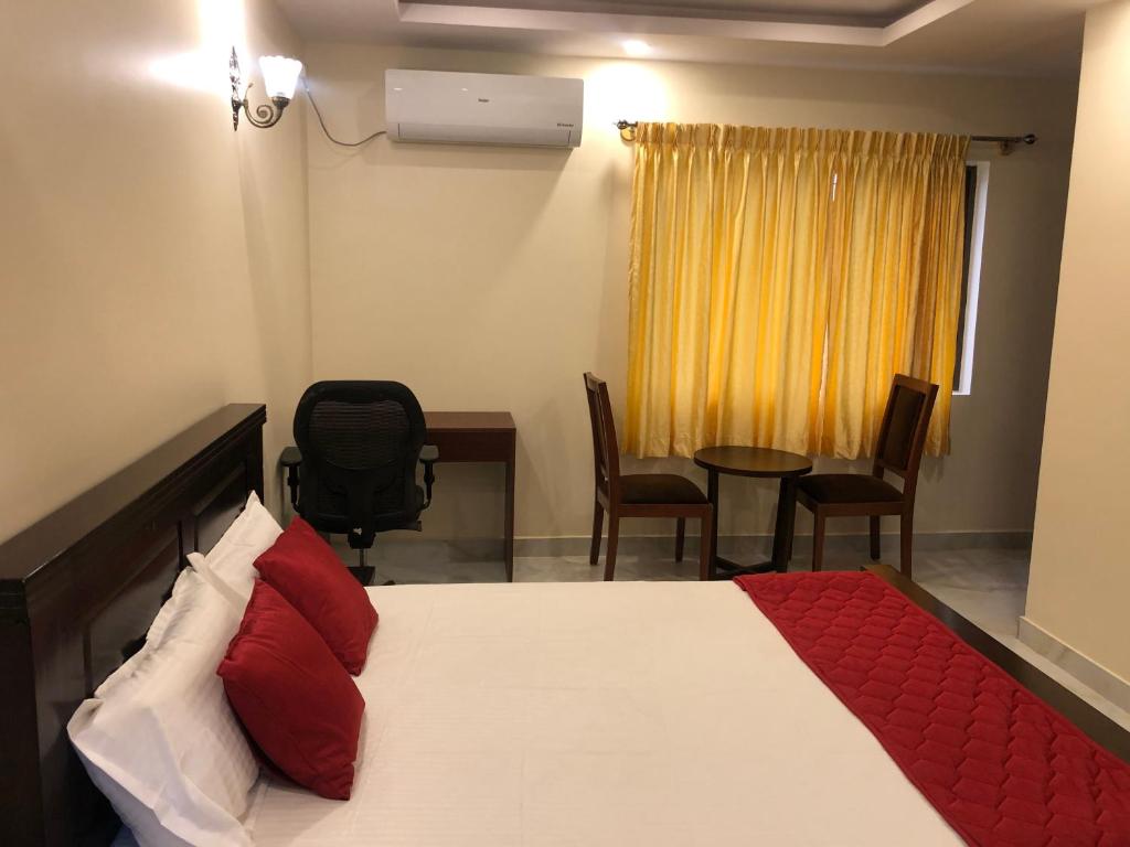Un dormitorio con una cama y una mesa y sillas. en Family Friendly Studio Apartment -3, en Bangalore