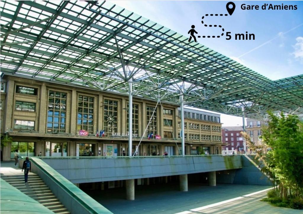 a building with a person walking under a glass roof at L Arcade Chic & Confort - Terrasse - 5 min Gare in Amiens