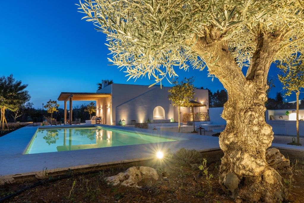 un árbol frente a una casa con piscina en Villa Panacea, en Gallipoli