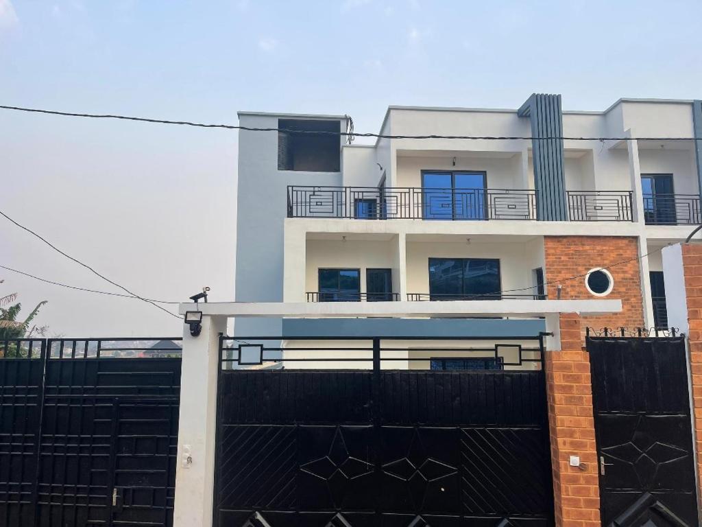 a white house with a black fence and a building at Cozy'K Home in Biting