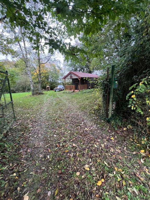 un chemin menant à une maison avec une clôture dans l'établissement Mon chalet dans le Perche, à Charbonnières
