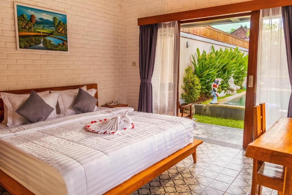 a bedroom with a large white bed with a window at Villa Mulia - 2BR Canggu Bali in Dalung
