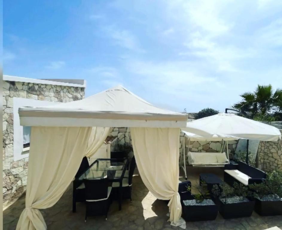 a patio with an umbrella and a table and chairs at Villa Lucia in Lampedusa