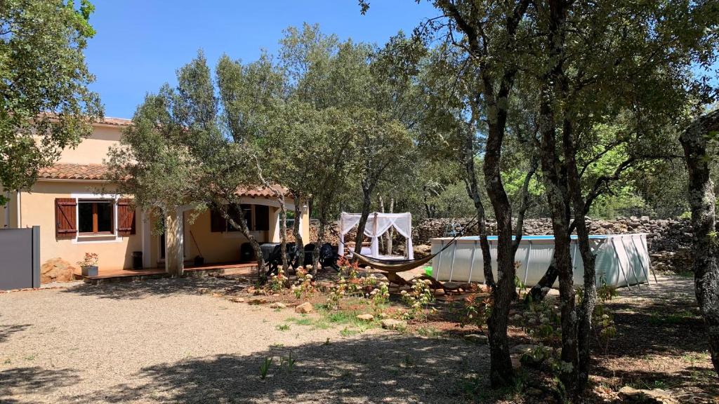 a house with a boat in a yard with trees at gite le repos des chênes option spa extérieur Evasion nature et confort ! in Régusse