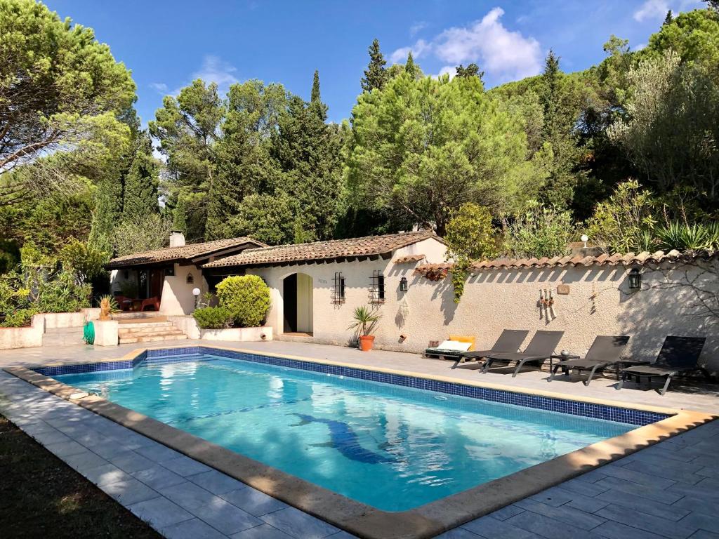 une piscine devant une maison dans l'établissement l'Exotica ,au cœur d'une pinède, à Palaja