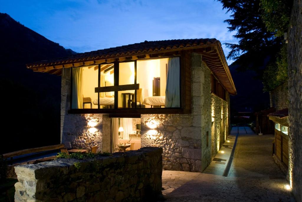 a small house with a window with lights on it at Apartamentos Rurales El Lleron in Caso