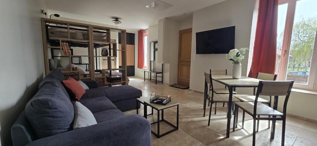 un salon avec un canapé bleu et une table dans l'établissement La Taupinière, à Bourges