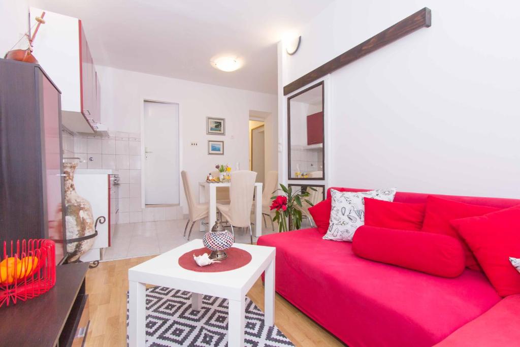a living room with a red couch and a table at Red Valentino Apartment in Split