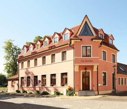 un grand bâtiment orange et blanc dans une rue dans l'établissement Hotel Zum Gondoliere, à Oranienbaum-Wörlitz